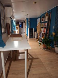 a living room with a table and a book shelf at Bateau Escapade in Ramonville-Saint-Agne