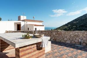 a stone table on a patio with a stone wall at Le Dimore di Mariuccia 1 in Monte SantʼAngelo