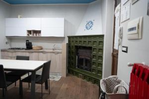 a kitchen with a fireplace with a table and chairs at Le Dimore di Mariuccia 1 in Monte SantʼAngelo +26 photos