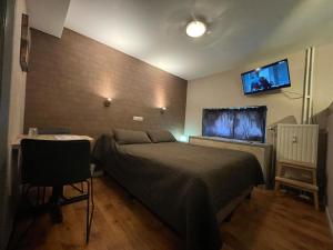 a bedroom with a bed and a flat screen tv at Hotel Les Arcades - La-Roche-en-Ardenne in La-Roche-en-Ardenne