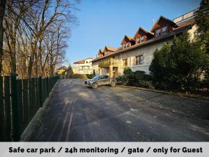 a car parked in front of a house on a street at Hotel Protea Bolesławiec in Bolesławiec