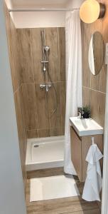 a bathroom with a shower and a tub and a sink at Sleep and Go Lyon Oullins in Oullins
