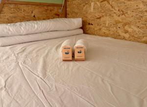 two pairs of slippers sitting on top of a bed at Sleep and Go Lyon Oullins in Oullins