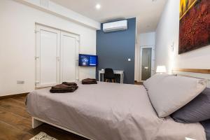 a bedroom with a large bed in a room with a desk at V86 - Charming 1 Bedroom Isla Duplex Apt with Harbour Views in Senglea