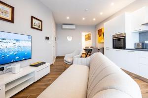 a living room with a couch and a tv at V86 - Charming 1 Bedroom Isla Duplex Apt with Harbour Views in Senglea