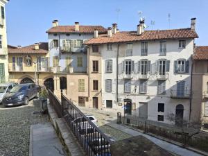 a group of buildings with cars parked in a parking lot at Il Nido della Piazzetta in Saluzzo