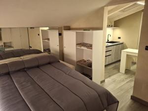 a bedroom with two beds and a kitchen at Il Nido della Piazzetta in Saluzzo