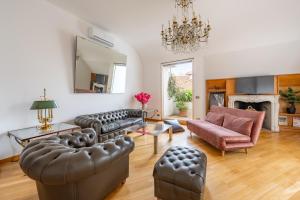 a living room with leather furniture and a fireplace at Imperial Terrace suite in Milan