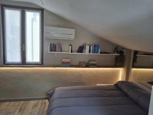 a bedroom with a bed and a window and a book shelf at Il Nido della Piazzetta in Saluzzo