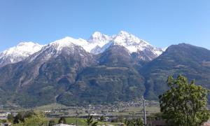 a snow capped mountain range with a town in front at Le Petit Soleil in Saint-Christophe +2 photos
