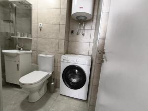 a bathroom with a toilet and a washing machine at SunBreeze in Igalo +3 photos
