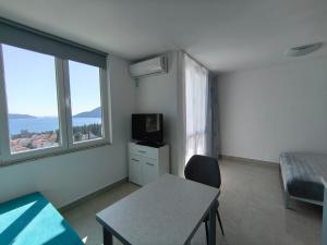 a room with a bed and a table with a tv at SunBreeze in Igalo