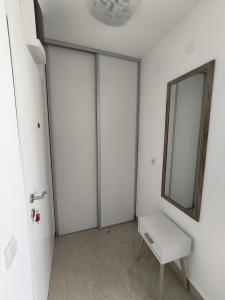a white room with a mirror and a stool at SunBreeze in Igalo