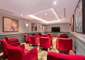 a waiting room with red chairs and a flat screen tv at Zenao Appart'hôtels Saint-Mandé in Saint-Mandé