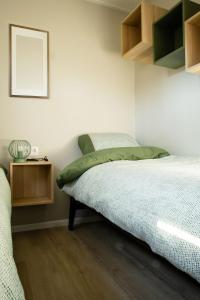 a bedroom with a bed and a wooden floor at Chalet Bosrijk in Haarle