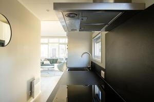 a kitchen with a sink and a living room at Chalet Bosrijk in Haarle