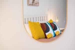 a mirror reflecting a bed with pillows on it at A unique experience in Porto in Porto