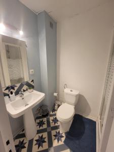 a bathroom with a white toilet and a sink at Chambre Lumineuse avec Balcon - Cuisine Partagée & Salle de Bain Privée in Lourdes