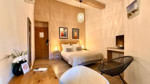 a hotel room with a bed and a chair at Hotel Le Galambre in Nîmes +55 photos