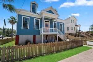a blue house with a wooden fence at Rustic Luxury - As Seen on "Restoring Galveston" TV Show in Galveston