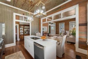 a kitchen and living room with wooden walls and a ceiling at Rustic Luxury - As Seen on "Restoring Galveston" TV Show in Galveston
