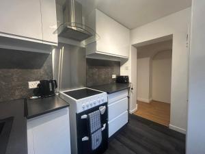 a kitchen with white cabinets and a stove top oven at Solway Firth View in Annan