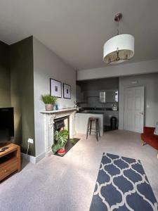 a living room with a fireplace and a kitchen at The Linen Loft - 2 Bed Apartment - Central Town Location - Reserved Parking Space Included in Ross on Wye