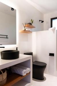 a bathroom with a black sink and a toilet at Serena Nosara Beach Retreat in Nosara +25 photos