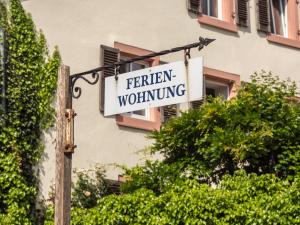 a sign for a farmer whining hanging from a building at Ferienwohnung Mona Lisa in Malterdingen