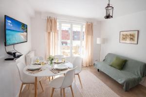 a white living room with a table and a couch at Le Caballo - Appartement de charme à Digoin in Digoin