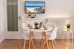 a dining room with a table with a laptop and chairs at Le Caballo - Appartement de charme à Digoin in Digoin