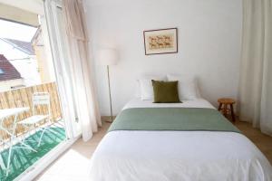 a bedroom with a bed and a large window at Le Caballo - Appartement de charme à Digoin in Digoin