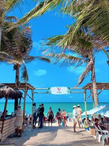 a group of people walking on the beach at Diamante dos Ventos Duplex com Piscina Cumbuco in Caucaia