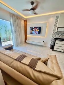 a large bed in a living room with a tv at Diamante dos Ventos Duplex com Piscina Cumbuco in Caucaia