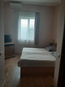 a small bedroom with a bed and a window at Готель Ніколет in Mukacheve