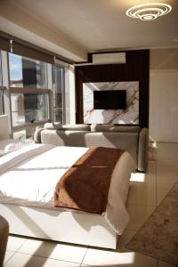 a bedroom with a large bed and a tv at HeartStay Shkodra in Shkodër
