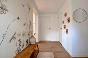 a hallway with a white wall with drawings of flowers on it at Casa Allocco in Norg +43 photos
