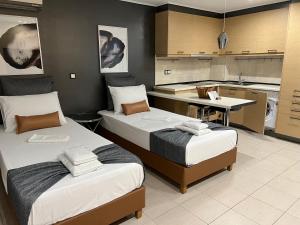two beds in a room with a kitchen at NJ Lavrio in Lavrio