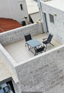 a patio with two chairs and a table on a building at NJ Lavrio in Lavrio