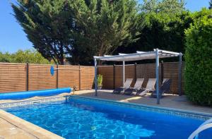 a swimming pool with two chairs and an umbrella at Maison du Figuier 1799 in Nanclars +20 photos