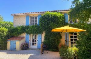 a yellow umbrella in front of a house at Maison du Figuier 1799 in Nanclars