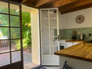 a kitchen with an open door to a garden at Maison du Figuier 1799 in Nanclars