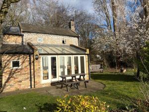 a house with a picnic bench in front of it at The Old Post Office, Hilton in Huntingdon +11 photos