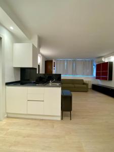 a kitchen with white cabinets and a living room at ANTONELLA's ROOM in Bresso