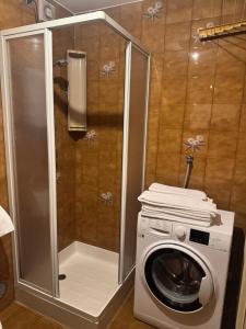 a washing machine in a bathroom with a shower at Campiglio Monolocale Cima Tosa in Madonna di Campiglio +3 photos