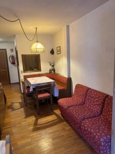 a living room with a couch and a table at Campiglio Monolocale Cima Tosa in Madonna di Campiglio