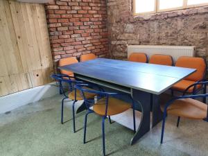 a conference room with a blue table and orange chairs at Kennedy House in Lyetnitsa