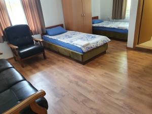 a room with a bed and a chair and a couch at Kennedy House in Lyetnitsa +8 photos
