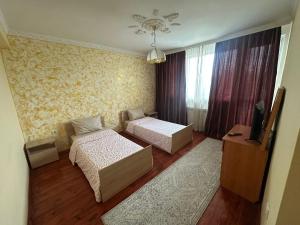 a living room with two beds and a television at Kennedy House in Lyetnitsa