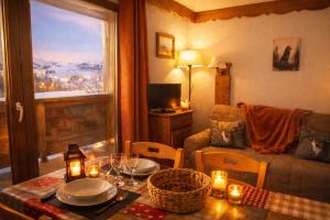 a living room with a table with candles and a couch at T2 cosy 4 pers balcon vue montagne la Joue du loup in Le Dévoluy